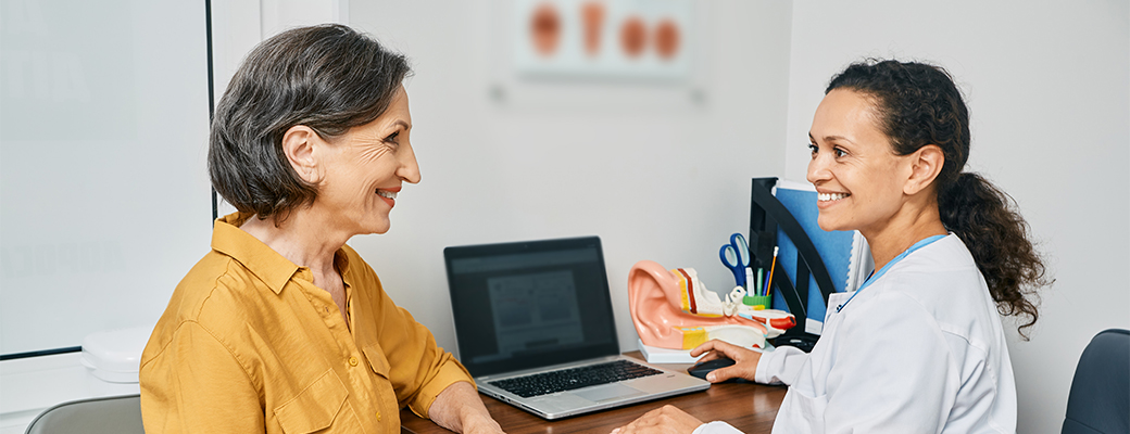 Image of senior woman speaking to a female hearing care professional